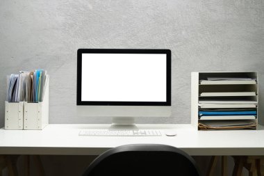 Boş ekran bilgisayar, lamba, kalem tutacağı ve saksı bitkisi beyaz masada. Web sayfan için boş görünüm veya metni tanıt.