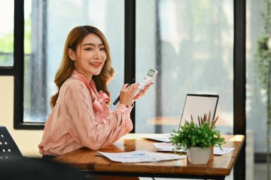 Cazip kadın analist, dizüstü bilgisayardaki pazarlama araştırma sonuçlarını ya da istatistik verilerini kontrol ediyor..