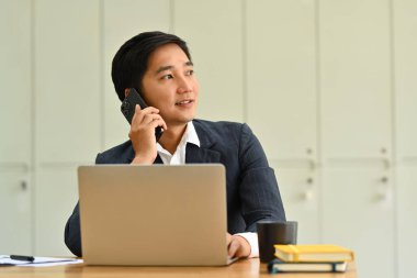 Yakışıklı bir milenyum işletmecisi telefon görüşmesi yapıyor ve başka tarafa bakıyor. İş, teknoloji ve iletişim.