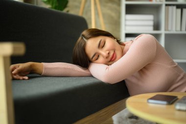 Serene genç Asyalı kadın kanepede uzanıyor, uzak çalışma gününde evde mola veriyor..