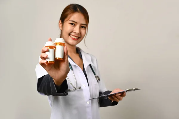 友善微笑的医生拿着装有空白白色标签的药瓶 白色背景隔离 — 图库照片