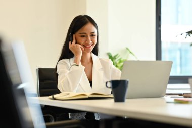 Güzel bir kadın analist dizüstü bilgisayardan internetten webinar izliyor. İş, iletişim ve teknoloji.