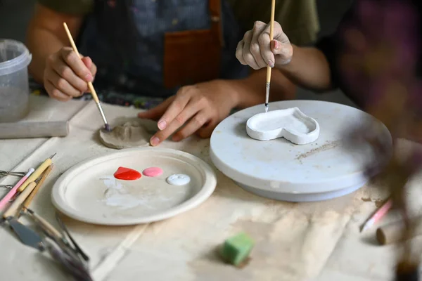 两名年轻人在陶瓷作坊里手工制作陶瓷盘 — 图库照片