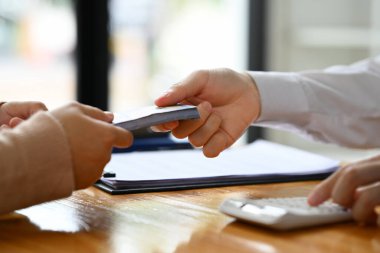 Yakından bakan adam kadın müşteriye nakit para veriyor. Döviz kurları, kredi onaylı finans ve bankacılık kavramı.