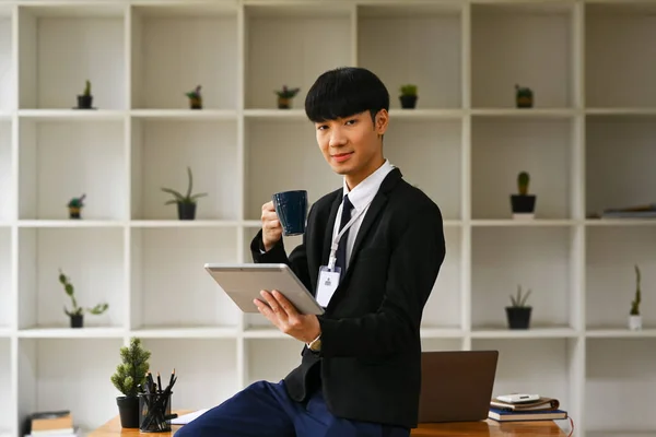 Asyalı Işadamı Sıcak Kahve Içiyor Modern Ofiste Dijital Tablet Kullanıyor — Stok fotoğraf