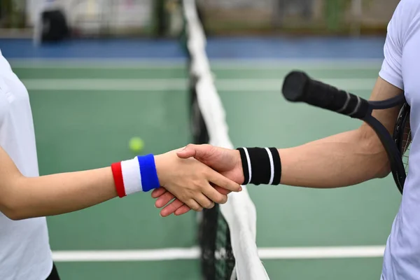 試合後にテニスコートで握手する2人の若いテニス選手のトリミングされた画像 — ストック写真