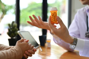 Doktorun hastaya ilaç dozajını açıklarken görüntüsü. Tıp, sağlık ve insan konsepti.