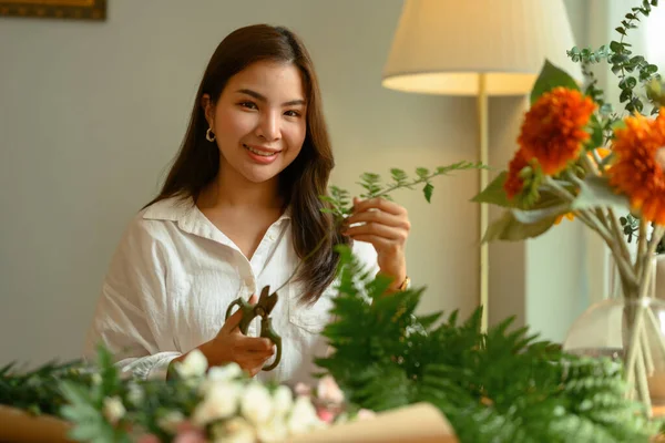 魅力的な若い主婦作成美しい花束で異なる花で居心地の良い家 — ストック写真