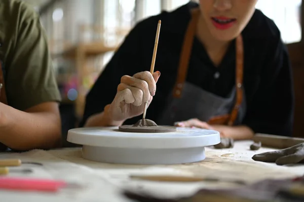 年轻的有创意的人专注于在陶器车间的桌子上雕刻生土 手工艺 创造力 业余爱好和活动概念 — 图库照片