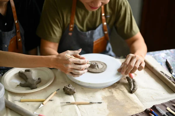 陶瓷艺术教师在课堂上帮助学生粉刷粘土板 — 图库照片