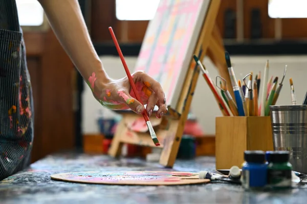 艺术家站在画架前 将画笔浸入彩色调色板中的剪影 — 图库照片