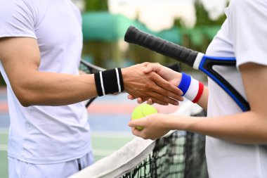 Tenisçiler maçtan sonra el sıkışıyor. Spor, eğitim, rekabet ve aktif yaşam konsepti.