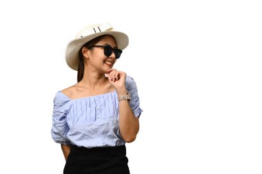 Güneş gözlüklü ve şapkalı gülümseyen kadın, beyaz arka planda izole uzay düşmanı reklamı ya da promosyon metni ile yan bakıyor.