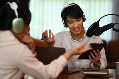 Ev sahibi stüdyodan canlı yayında kulaklıkla radyo sunucusu ve konuklarıyla çeşitli konuları tartışıyor..