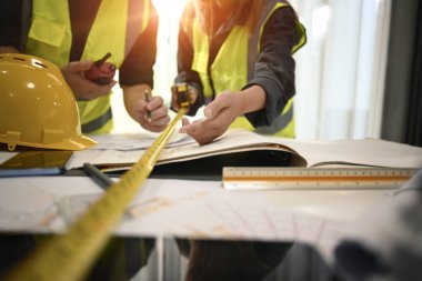 Proje üzerinde çalışan, işbirliği yapan, toplantı odasında birlikte çalışmayı planlayan mimarların görüntüsü.