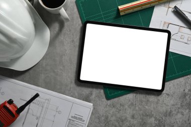 Dijital tablet, güvenlik kaskı, planlar ve Mimarlar 'ın işyeri hakkında telsiz..