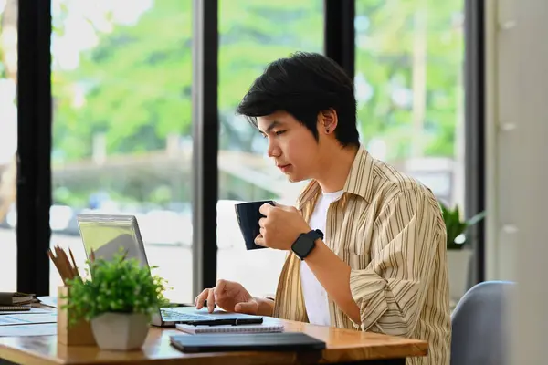 Asyalı Adamı Şık Giyiniyor Kahve Içiyor Ofiste Dizüstü Bilgisayar Kullanıyor — Stok fotoğraf