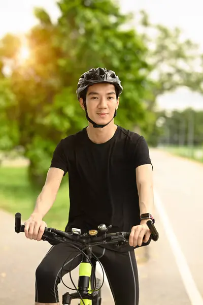 Sıradan Giyinmiş Kasklı Gülümseyen Asyalı Bir Adam Bisiklet Yolunda Bisiklet — Stok fotoğraf