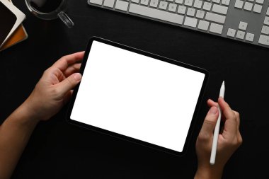 Siyah ahşap masada dijital tablet kullanan bir adamın görüntüsü reklam mesajınız için boş..
