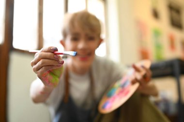 Elleri suluboya boya fırçalarla kirletilmiş ressamların odak elini seçin. Sanat, hobi ve eğlence etkinliği konsepti.