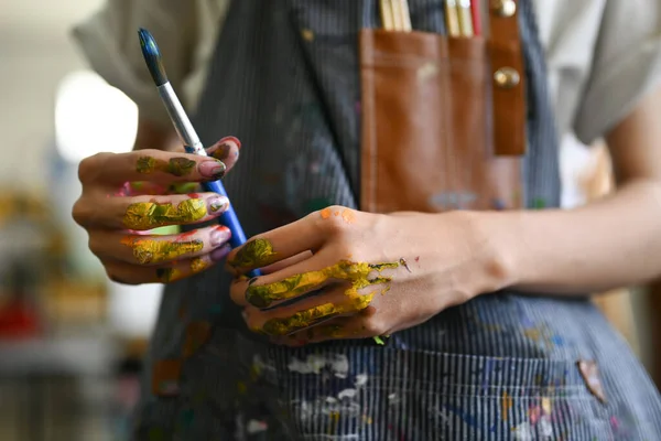 stock image Artist hands soiled with watercolor paints holding brushes and smiling to camera. Art, hobby and leisure activity concept.
