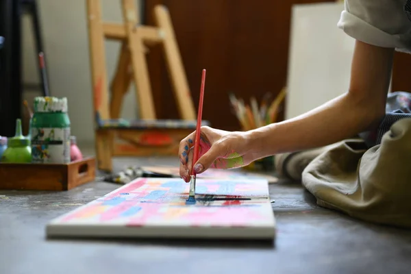 男艺术家坐在艺术工作室的地板上 用水彩画在画布上 创意业余爱好和艺术概念 — 图库照片