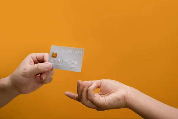 stock image Hands of man passing a payment credit card to the seller. Electronic money, transaction and banking concept.