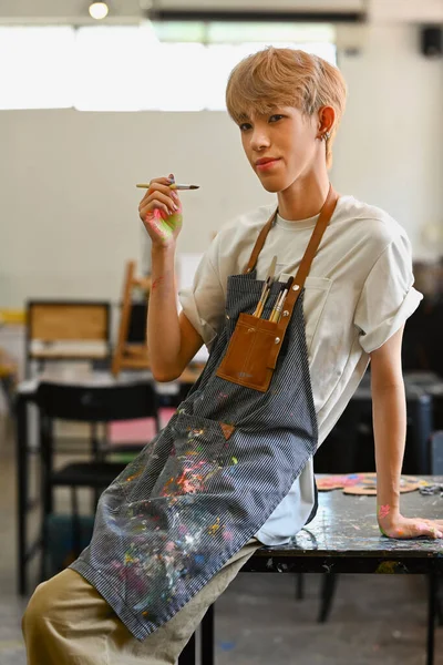 Portrét Mladého Gaye Zástěře Držícího Štětec Usmívajícího Kamery Umění Vzdělávání — Stock fotografie