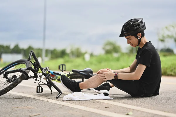 Bisiklet kazası. Bisiklet kazası geçiren genç bir bisikletçi, bisikletten düşüp dizini sakatladı..