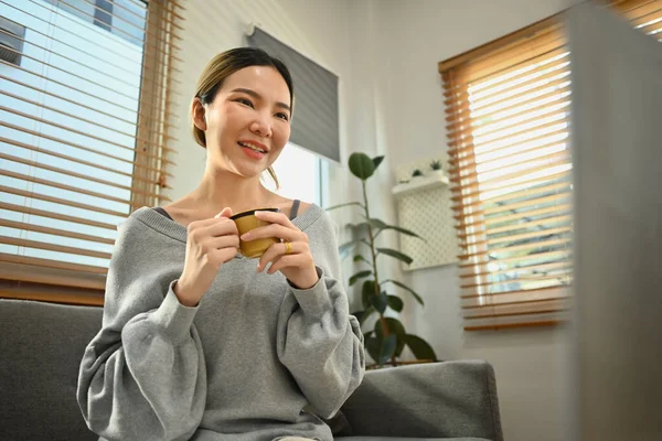 快乐的女人在家里喝咖啡 使用笔记本电脑 看电影和上网购物 — 图库照片