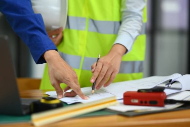 Mimarlar ekibinin proje üzerinde çalışırken, işbirliği yaparken, planlama yaparken, toplantı odasında birlikte çalışırkenki görüntüsü..