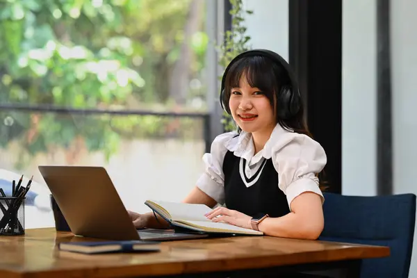 オンライン教育 Eラーニング ヘッドフォンを装着し ノートパソコンを使って遠隔で勉強する幸せなアジアの若い女性 — ストック写真