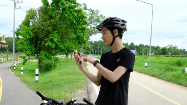 Bisikletinin Yanında Duran Yakışıklı Asyalı Bisikletçi Akıllı Adam Hakkındaki Spor — Stok video