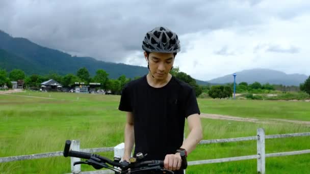 Genç Asyalı Adam Akıllı Hareketlerini Kuruyor Kırsal Bir Yolda Bisiklet — Stok video