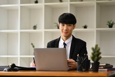 Pozitif işadamı yöneticisi dizüstü bilgisayar kullanıyor ve ekonomi raporu veya ofis masasında sunum hazırlıyor.