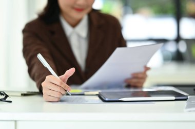 Önemli notlar ya da evrak işleriyle ilgili yeni bir fikir içeren iş kadını ellerine odaklanmayı seçin.