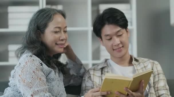 Щасливі Бабуся Молодий Дорослий Онук Читають Книгу Насолоджуються Проведенням Часу — стокове відео
