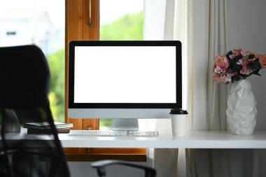 Boş masaüstü bilgisayarı, saksı bitkisi ve beyaz masadaki kitaplar. Reklam metniniz için beyaz ekran.