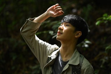 Ormanda yürüyüşe çıkan ve doğanın tadını çıkaran mutlu erkek yürüyüşçü. Macera, keşif ve seyahat kavramı..