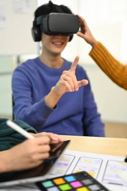 Sanal gerçeklik deneyimi olan sanal gerçeklik kulaklığı takan genç yaratıcı adam, yeni dijital projeler hakkında görüşme yapacak.