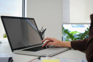 Bilgisayarda online bilgi arayan ve ofisteki raporlarla çalışan kadın girişimci.