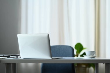 Bilgisayarı, kahve fincanı, bardakları ve malzemeleri olan rahat bir ofis masası..