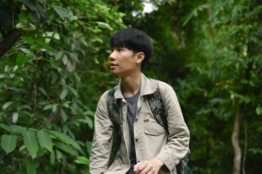 Sırt çantasıyla ormanda doğa keşfi yapan çekici bir bayan yürüyüşçü. Seyahat, yürüyüş ve macera konsepti.