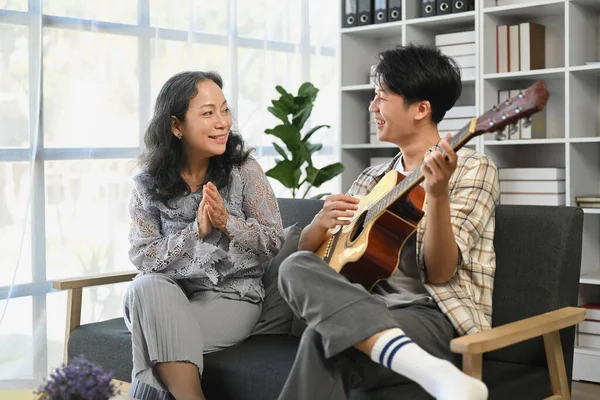 Relationship concept ,Grandmother and a man joyful with music on sofa..