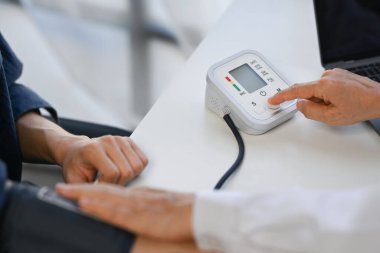 Doktor klinikteki erkek kan basıncını ölçüyor. Yüksek tansiyon, sağlık hizmeti konsepti.