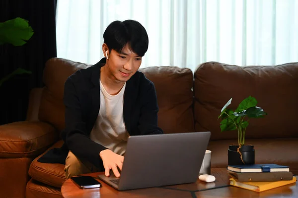 穿着时髦休闲装的英俊男性穿着浏览互联网 远程工作或呆在家里的笔记本电脑上 — 图库照片