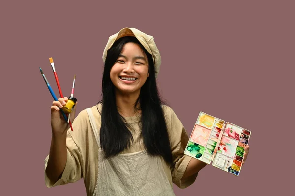 快乐的少女拿着调色板 粉刷着粉红的背景 创意和教育概念 — 图库照片
