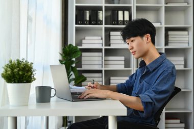 Modern ofiste dizüstü bilgisayarla çalışan bir adam...