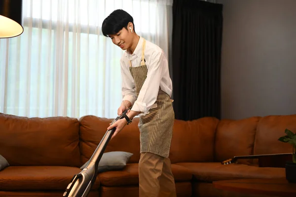 Schöner Mann Mit Schürze Saugt Teppich Reinigt Den Staub Auf — Stockfoto