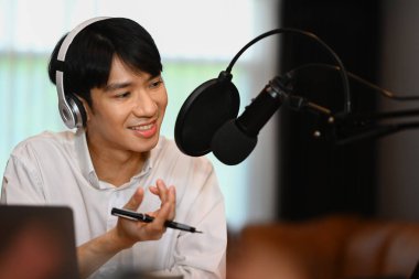 Gülümseyen adam içerik yaratıcısı mikrofon aracılığıyla konuşuyor kanal için konuşma kaydı için.